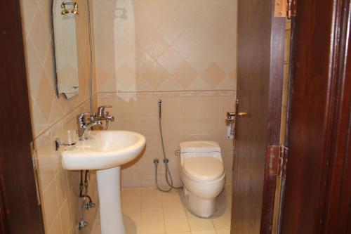 a small bathroom with a toilet and a sink at Makarim Najd 4 in Riyadh