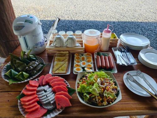a wooden table with plates of food and drinks at Greenview Room and Restaurant 