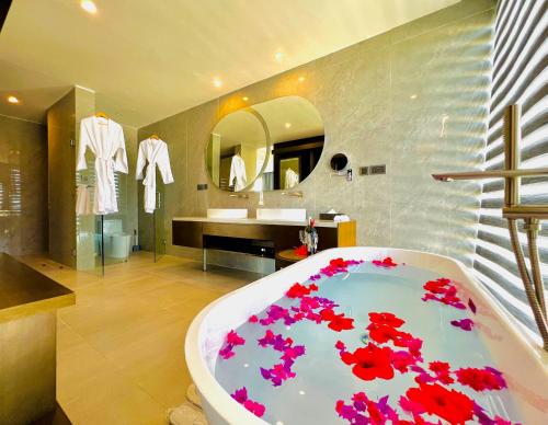 a bathroom with a tub with red flowers on it at Matemwe Sands Hotel in Mkuyuni Pwani