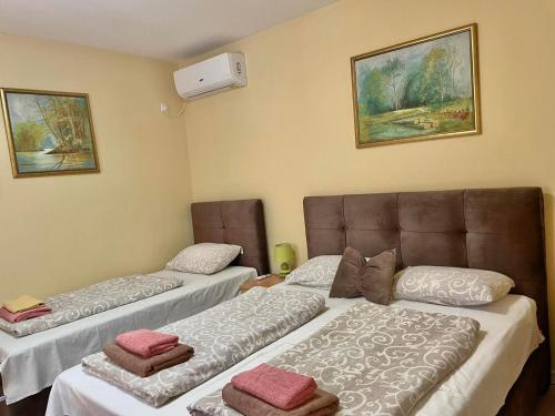 een kamer met 2 bedden en een bank bij Prenoćište Vila Stara Breza in Palić