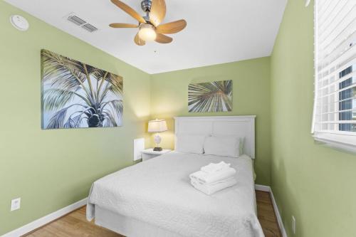een slaapkamer met een wit bed en een plafondventilator bij 1st Ashore-Beachfront-Pet Friendly in St. George Island