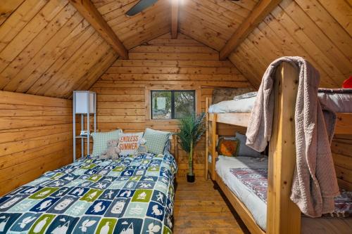 een slaapkamer met een bed in een houten hut bij Starlite Vintage Resort in Buckskin Joe