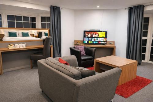 a living room with a bed and a couch and chairs at Hotel Express Newcastle Gateshead in Newcastle upon Tyne