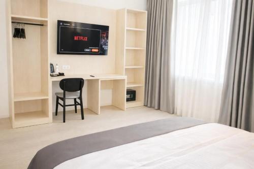 una camera d'albergo con un letto, una scrivania e una TV di Niko Hotel am Hannover Hbf ad Hannover