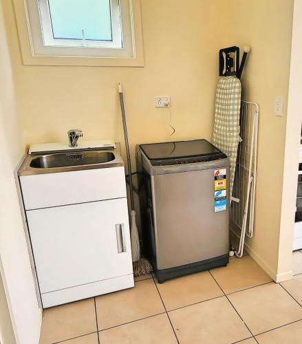 a kitchen with a sink and a refrigerator at Entire House 15 min CBD Near Beach Mall and Nature in Auckland