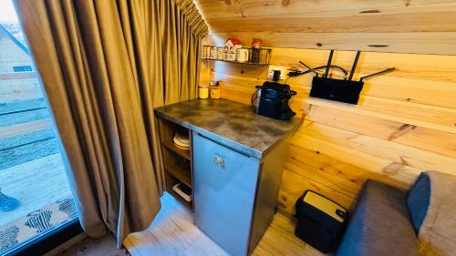 a kitchen with a counter in a tiny house at Tiny A-Frame Cabin with Private Hot Tub & Views - Perfect for 2 in Şelari