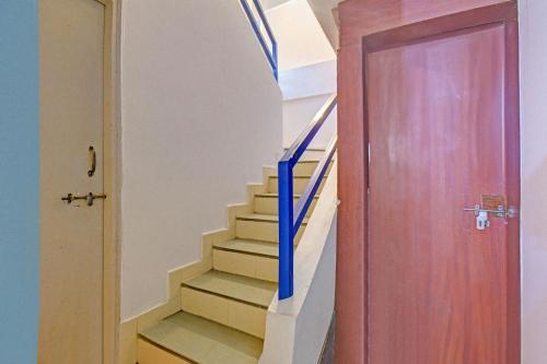 un escalier avec une rampe bleue et une porte dans l'établissement FabHotel Nisarg Villa, à Pune