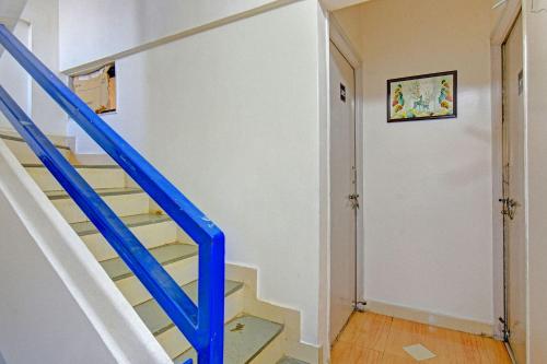 un escalier bleu dans une maison avec une rampe bleue dans l'établissement FabHotel Nisarg Villa, à Pune
