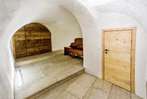 a hallway with a door and a bed in a room at Chesa Chamuera in La Punt-Chamues-ch