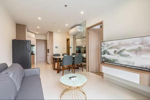 - un salon avec un canapé et une grande télévision dans l'établissement Homie Apartmant l Vinhomes Grand Park, à Hô-Chi-Minh-Ville