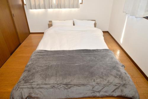 a bed with a blanket on the floor in a room at 高岡ゆるり家 Yururi-Ya in Takaoka