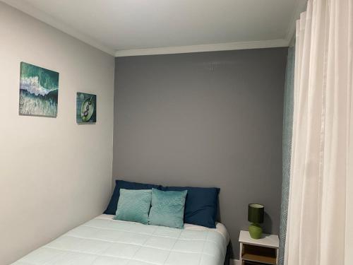 een slaapkamer met een bed met blauwe kussens erop bij Aveiro Studio Alboi in Aveiro