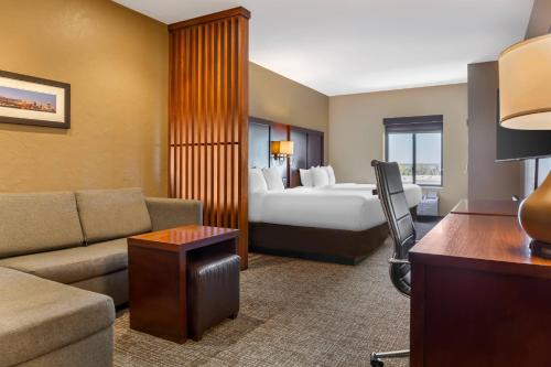 a hotel room with a bed and a couch at Comfort Suites Florence - Cincinnati South in Florence