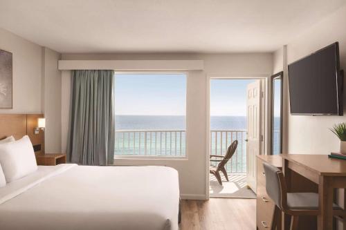 a hotel room with a bed and a view of the ocean at Radisson Beachfront Hotel - Panama City Beach in Panama City Beach