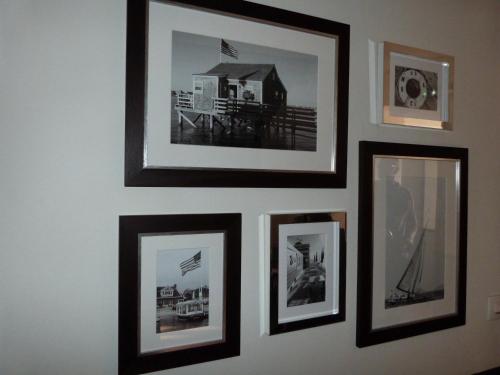 a group of framed pictures on a wall at Hotel Les Embruns in Le Touquet-Paris-Plage