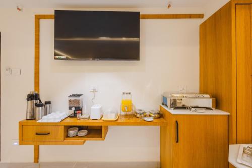 eine Küche mit einer Theke mit einem Toaster und einer Mikrowelle in der Unterkunft Treebo Ss Residency Gandhi Nagar in Vijayawāda