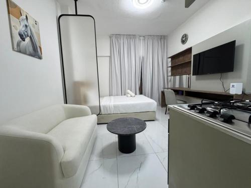 a living room with a couch and a table in a room at Luxury Apartment with Pool Gym & Free Parking at Equiti Gates Jebel Ali in Dubai