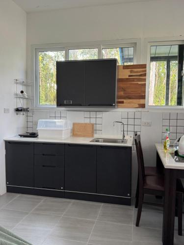a kitchen with a sink and a microwave at Woodland Residence in Wok Tum