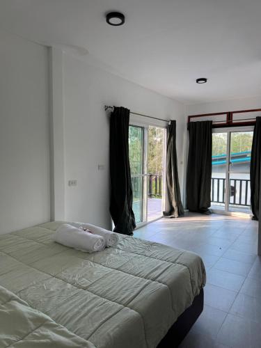 a bedroom with a bed and a large window at Woodland Residence in Wok Tum