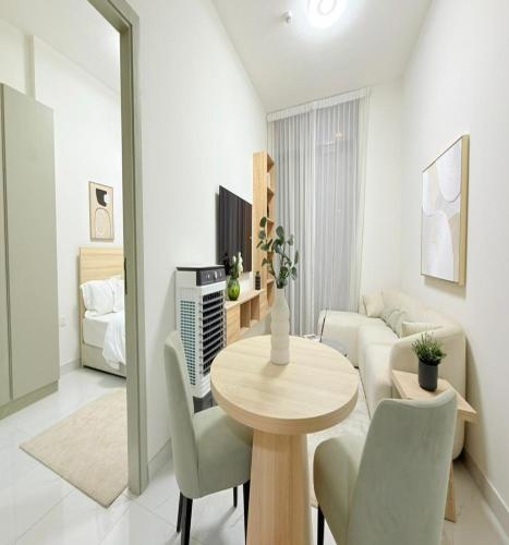 a living room with a table and a couch at Luxury Apartment with Pool Gym & Free Parking at Equiti Gates Jebel Ali in Dubai