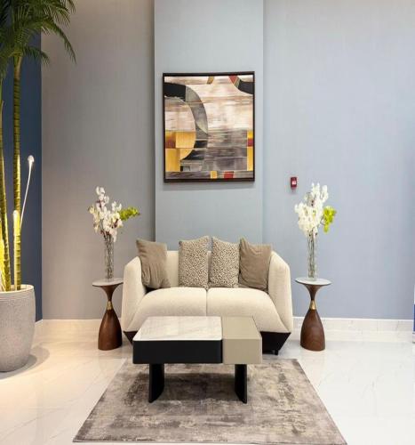 a living room with a couch and a coffee table at Luxury Apartment with Pool Gym & Free Parking at Equiti Gates Jebel Ali in Dubai
