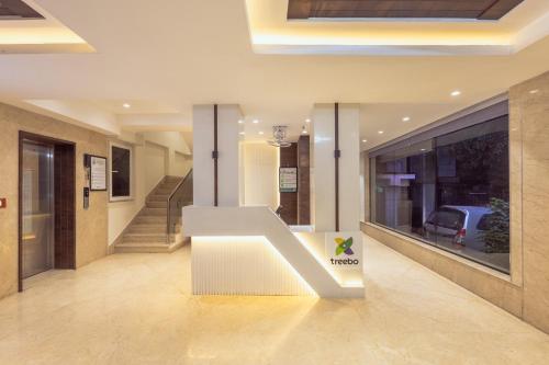 eine Lobby mit einer weißen Bank in einem Gebäude in der Unterkunft Treebo Ss Residency Gandhi Nagar in Vijayawāda