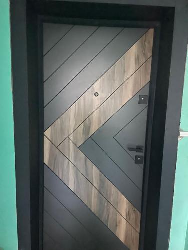una porta in legno con un design geometrico sopra di Mini House Shumen a Shumen