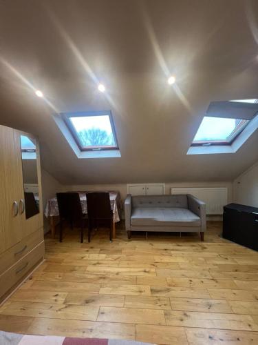 a living room with skylights and a couch in a room with a table at Spacious and Modern En-suit in Harrow on the Hill