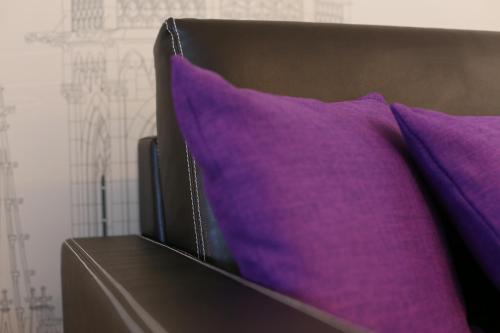 two purple pillows sitting on top of a bed at Schiller 5 Hotel in Munich