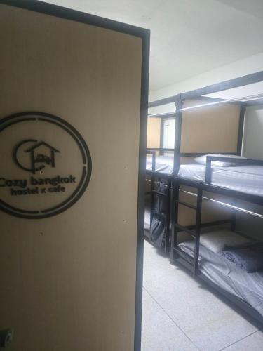 a room with bunk beds and a sign on the wall at Cozy bangkok hostel in Bangkok