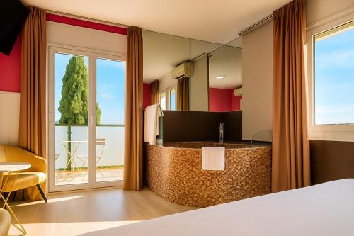 una camera d'albergo con un letto e una grande finestra di Hotel Consentido a Granollers