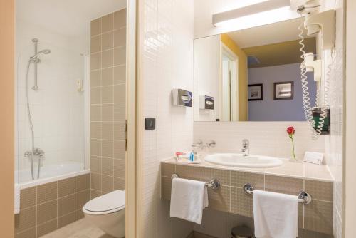 a bathroom with a sink and a toilet and a mirror at Hotel Garden Istra Plava Laguna in Umag