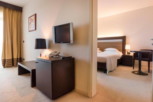 a hotel room with a bed and a television at Hotel Garden Istra Plava Laguna in Umag