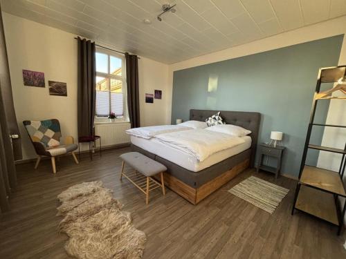 une chambre avec un grand lit et une chaise dans l'établissement NEU! Ferienwohnung Zwei Linden, à Uthlede