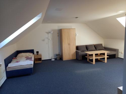 een kamer met een bed, een bank en een tafel bij Penzion Adam - Makov in Makov