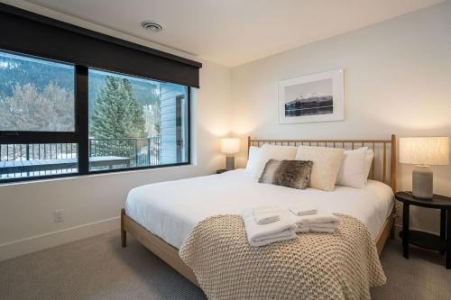 a bedroom with a bed and a large window at Qs Hideaway in Mackenzie Village in Revelstoke