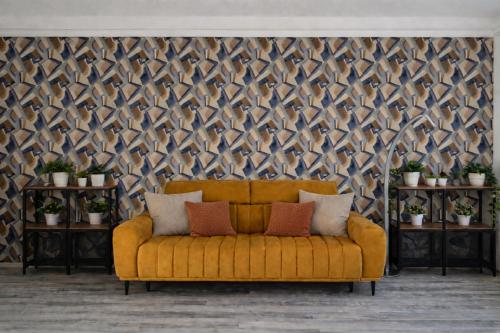 un canapé jaune dans une pièce avec un mur dans l'établissement Comfort 18 Real Family Home, à Miskolc