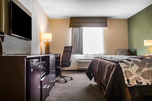 a hotel room with a bed and a television at Sleep Inn & Suites East Syracuse in East Syracuse