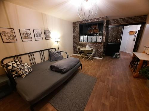 a bedroom with a bed and a table in a room at Studio agréable dans résidence in Joué-lès-Tours