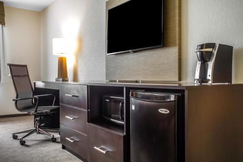 a hotel room with a refrigerator and a tv at Sleep Inn & Suites East Syracuse in East Syracuse