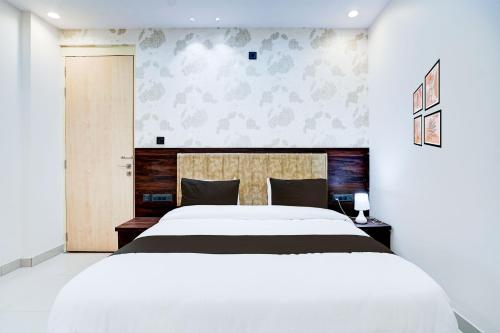 een witte slaapkamer met een groot wit bed. bij Townhouse Oak Ram Lala Mandir Kanpur Formerly Hotel Sun Rise in Kaliānpur