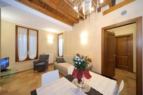 a living room with a couch and a table with flowers at Antico Teatro signorile in Salò