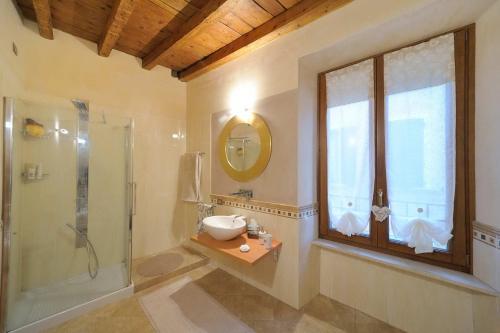 bagno con lavandino, doccia e specchio di Antico Palazzo Signorile a Salò