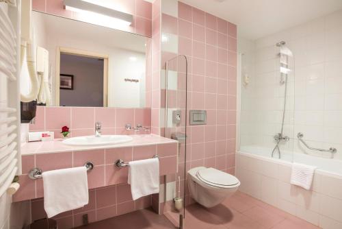 a pink bathroom with a sink and a toilet at Hotel Garden Istra Plava Laguna in Umag