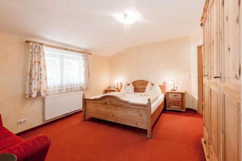 1 dormitorio con cama de madera y ventana en Alimonte Romantic Appartements, en Sankt Johann in Tirol