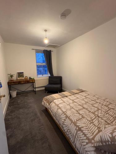 a bedroom with a bed and a chair and a desk at NextDoor Morden in Merton