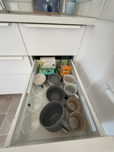 a drawer in a refrigerator filled with pots and pans at Wunderschöne Wohnung direkt am St Johanner Markt in Saarbrücken
