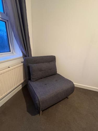 a chair sitting in a room next to a window at NextDoor Morden in Merton