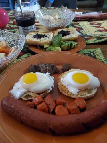 ein Frühstücksteller mit Eiern und Wurst in der Unterkunft Lavish 1BHK Apartment in Rawalpindi