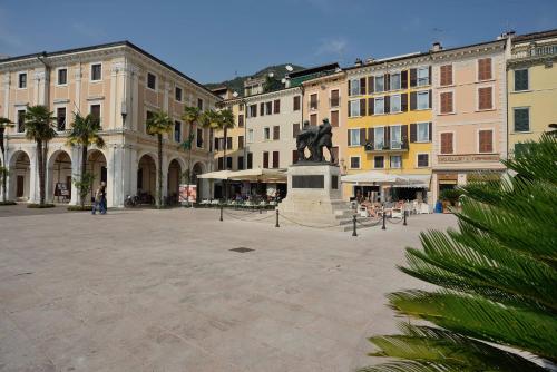 a square with a statue in the middle of a city at Antico Teatro signorile in Salò